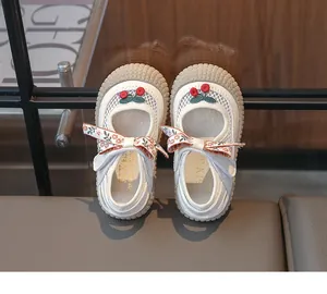 Vue détaillée des chaussures princesse enfant avec broderie cerise et noeud floral