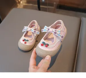 Détail de chaussure Mary Jane rose pour fille avec résille, cerise et nœud fleuri