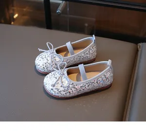 Detail of silver sequin ballet flats with light blue bow and elastic strap for girls