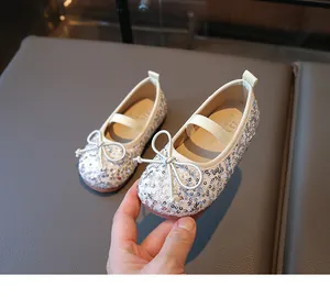 Detailed macro of silver sequin ballet flats with a delicate bow and elastic strap