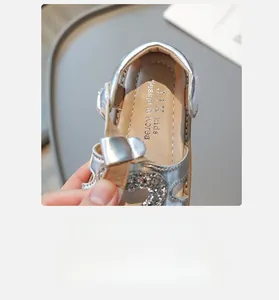 Détail de sandale argentée pour enfant avec motif cœur brillant et doublure en cuir doux