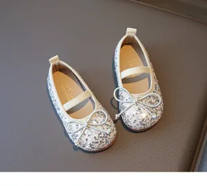 Detail of silver sequin Mary Jane flats featuring a bow accent and elastic strap