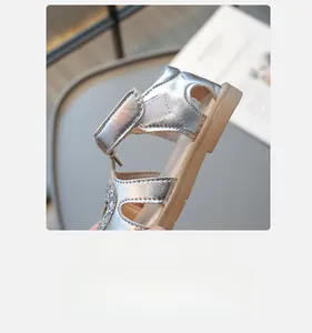 Détail de sandales argentées pour filles montrant la fermeture à velcro pratique