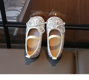 Close-up of girls silver sequin ballet flats with bow detail and elastic strap