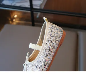 Close-up of sparkling silver sequins and elastic strap on ballet flats for girls