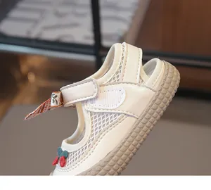 Détail de la sandale ajourée pour fille avec broderie cerise et fermeture velcro