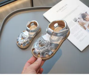 Détail de sandales argentées pour filles avec cœur à paillettes et design ajouré