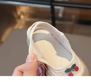 Détail d'une chaussure enfant en mesh respirant avec broderie cerise et semelle souple