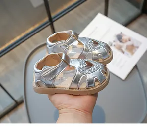 Détail de sandales argentées pour enfants avec paillettes cœur et sangle velcro