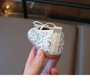 Detail shot of sparkling silver sequins and back strap on ballet flat shoes for girls