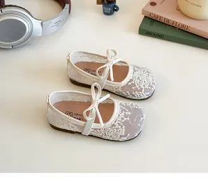 Détail de la broderie en dentelle florale et du nœud sur les chaussures Mary Jane