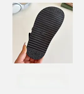 Detail shot of black kids' sandal sole with size 28 and anti-slip wavy texture