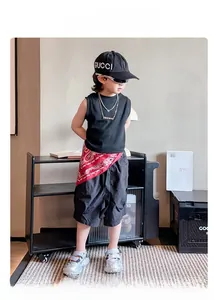 Kinder-Streetwear-Outfit mit schwarzer Weste, Paisley-Gürtel und silbernen Sneakern