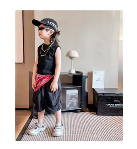Mädchen-Outfit im Street-Style mit schwarzer Weste, Shorts und silbernen Sandalen