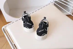 Détail de sandales bébé à bout fermé avec trous d'aération et bride à scratch
