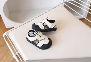 Vue détaillée des sandales bébé à bout fermé avec perforations et bride velcro beige