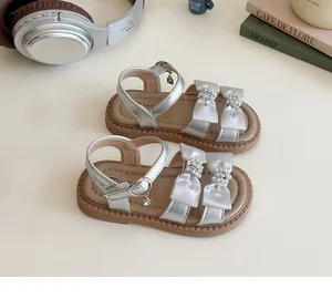 Macro detail van zilveren meisjessandalen met strassteentjes en antislip rubberen zolen