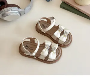Detail van prinsessensandalen voor meisjes met zijden strikken en gespen van strass-steentjes