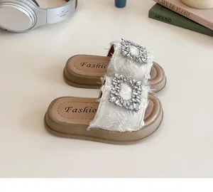 Primer plano de la hebilla de pedrería y textura de plumas en sandalias de plataforma