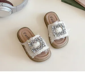 Detalle de sandalias de verano para niña con piel sintética y hebilla cuadrada de pedrería