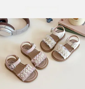 Dettaglio di sandali da principessa per bambina con perle delicate e ruches in mesh