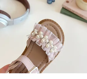Dettaglio dei sandali da principessa rosa per bambina con perle eleganti e pizzo fine