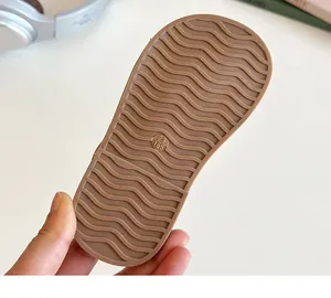 Dettaglio della suola in gomma marrone antiscivolo con texture a onde e taglia 23