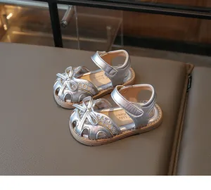 Detailed top view of silver baby sandals with bow decoration and hook-and-loop closure