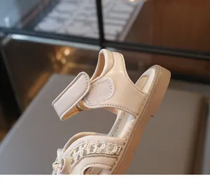 Detail of girls' sandals featuring lace mesh material and a secure Velcro strap closure
