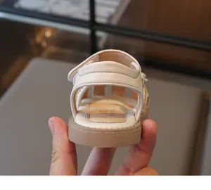 Detailed view of beige girl's sandal featuring adjustable velcro strap and rubber sole