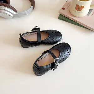 Detail of black hollowed-out Mary Jane shoes with silver buckle and breathable holes