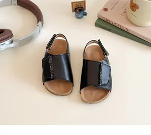 Detailansicht von schwarzen Kindersandalen mit Klettverschluss und Nähten von oben