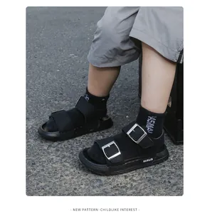 Close-up of kids black open-toe sandals with metal buckles and thick rubber soles