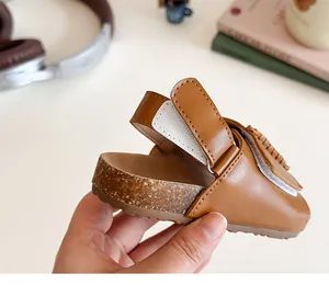 Detail von braunen Kindersandalen mit Kork-Textursohle und Klettverschluss am Riemen