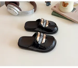 Dettaglio delle scarpe sabot da bambina in vernice nera con fibbia dorata