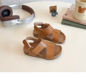 Detail of toddler cork-style sandals with brown leather H-strap and velcro closure