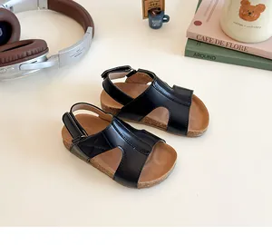 Close-up of kids' black cork sandals with soft soles and adjustable velcro straps