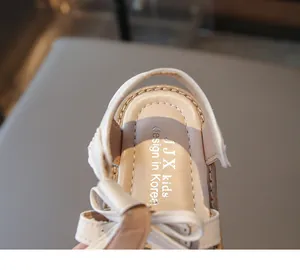 Nahaufnahme von beigen Kindersandalen mit Schleifendetail und Korea-Design-Logo