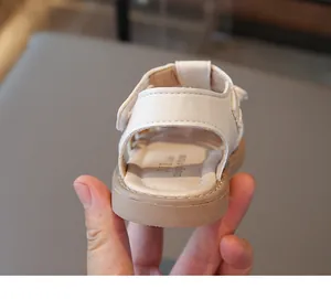 Detail von weißen Kinder-Sandalen mit rutschfester brauner Gummisohle und feinen Nähten