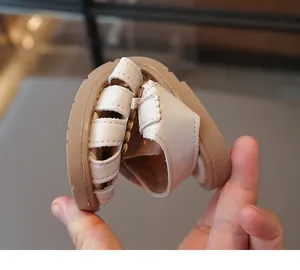 Demonstration der flexiblen Sohle bei cremeweißen geschlossenen Kleinkindsandalen