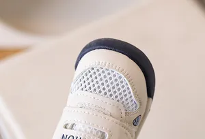 Macro detail of breathable mesh upper and protective navy rubber toe cap on toddler shoes