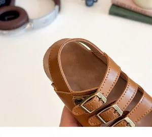 Gros plan de sandales Birkenstock marron pour tout-petits avec boucles en métal et cuir