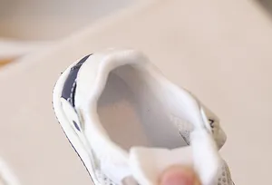 Close-up of breathable mesh fabric and padded heel support on toddler sports shoes