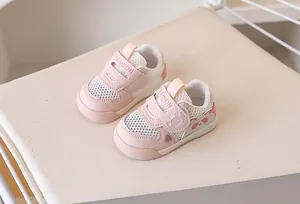 Close-up of pink and white toddler sneakers with breathable mesh and velcro straps