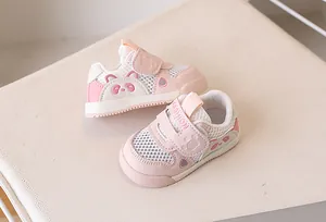 Macro detail of breathable mesh fabric and pink panda design on toddler walking shoe