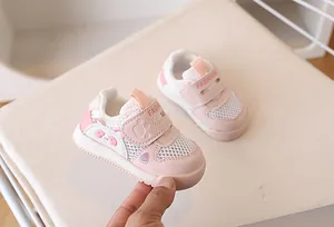 Close-up of flexible pink mesh toddler shoe with cute cat face and velcro closure