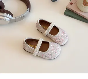 Close-up of glitter sequins and elastic strap on girl's pink Mary Jane flat shoes