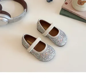 Detailed shot of sparkling sequin Mary Jane shoes with elastic strap and MMGZ logo