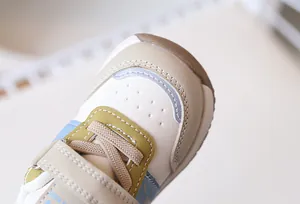 Dettaglio scarpa primi passi neonato con fori traspiranti e trama in pelle
