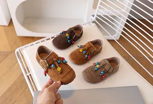 Close-up van suède kinderloafers met franjes, kleurrijke kralen en een gesp-sluiting